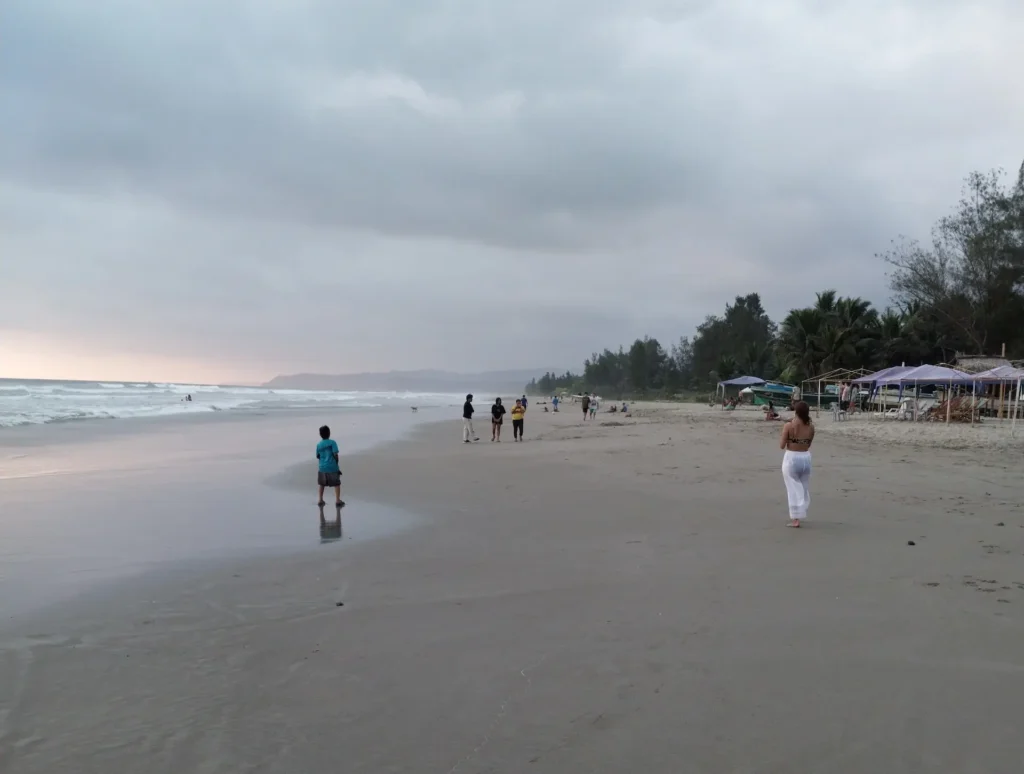 Olon beach Ecuador at sunset with locals walking along the shore
