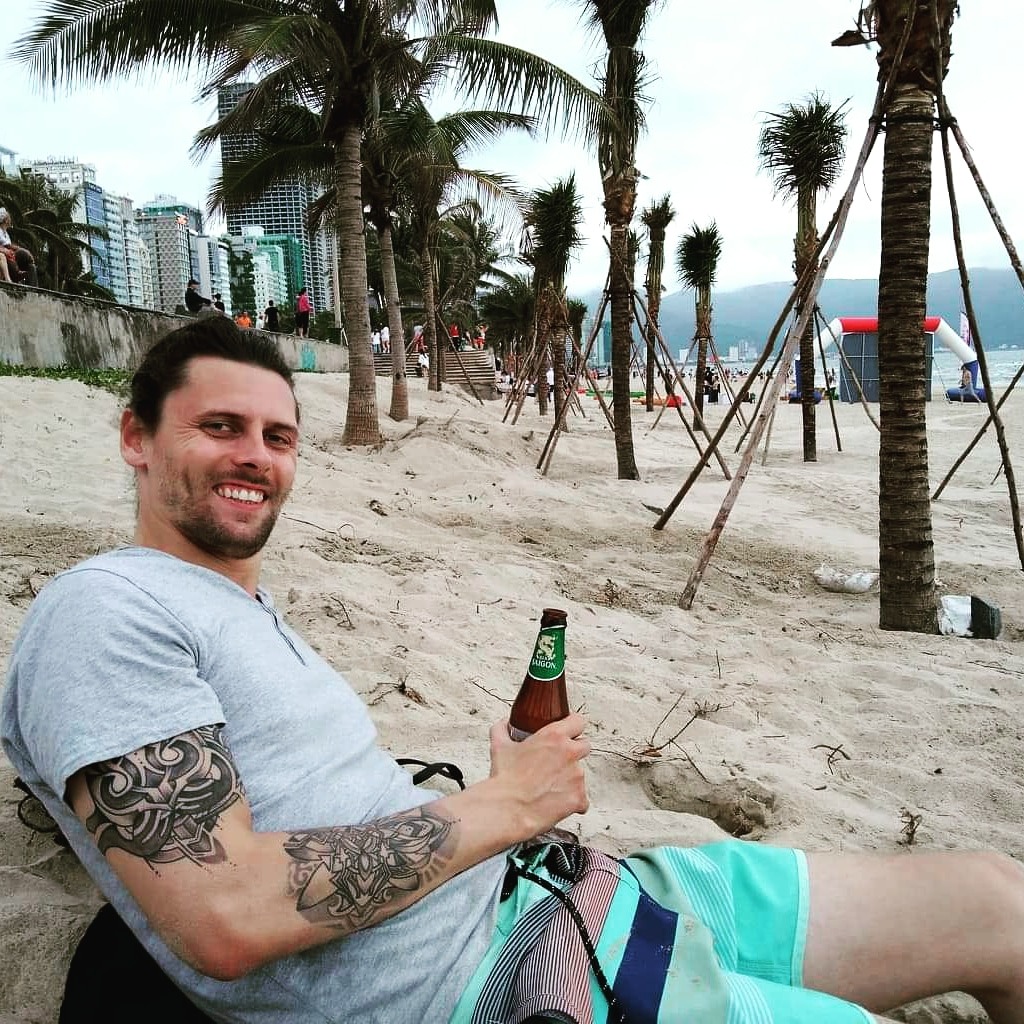 Me drinking a beer on Da Nang beach, Vietnam